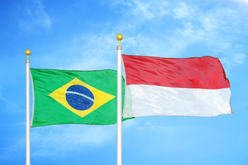 Brazil and Indonesia two flags on flagpoles and blue cloudy sky