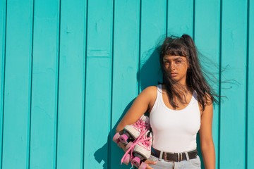 Young lady with roller skates against green background