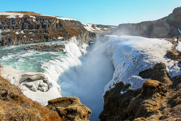 Fast and deep large waterfall in snow, in winter Iceland