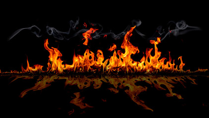 On fire flames at the black background, Burning red hot sparks rise, Fiery orange glowing flying particles