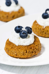 pumpkin cakes with cream and blueberries on white plate