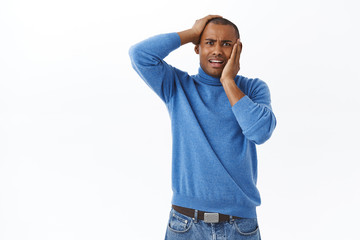 Portrait of panicking, young anxious embarrassed african-american male, concerned staring camera, gasping afraid of terrible situaton, hold hands on face and head, dont know what to do frustrated