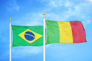 Brazil and Mali two flags on flagpoles and blue cloudy sky