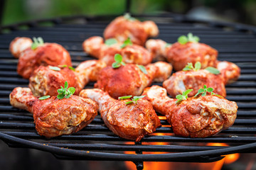 Closeup of spicy chicken legs with spices on grill