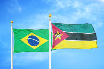 Brazil and Mozambique two flags on flagpoles and blue cloudy sky