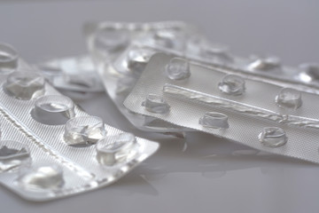 A pile used empty blister packs of tablets opened and empty without pills on grey background. Medical and healthcare concept.