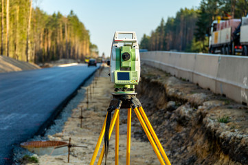 Surveyors equipment (theodolite or total positioning station) on the construction site of the road...