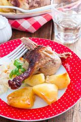 Chicken leg with potatoes on a plate on a wooden table, selective focus
