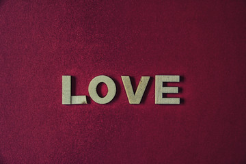 Fototapeta na wymiar Red background with the word love with wooden letters
