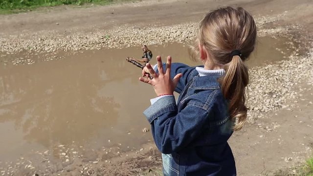 little girl shoots from a slingshot