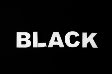 Black background with the word black with white woods letters