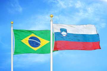 Brazil and Slovenia two flags on flagpoles and blue cloudy sky