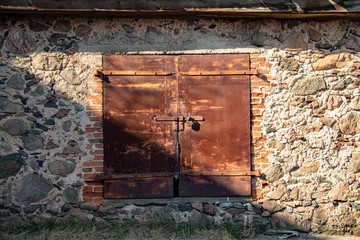 old iron rusty garage door with key. Stone masonry wall