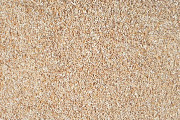 Texture of crushed wheat. Lots of yellow cereals on the pile.