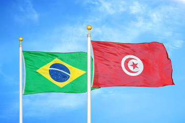 Brazil and Tunisia two flags on flagpoles and blue cloudy sky