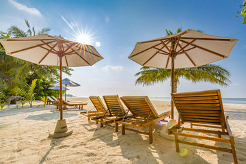 Beach beds and umbrellas on a tropical island. family vacation or summer holiday, beach landscape and shoreline, sunny weather, exotic destination.