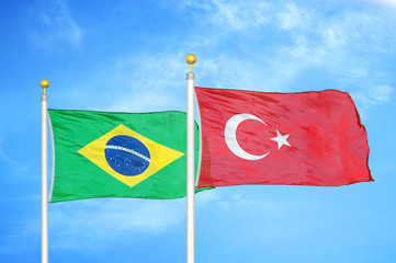 Brazil and Turkey two flags on flagpoles and blue cloudy sky