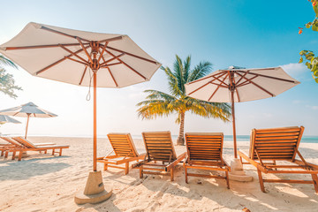 Beach beds and umbrellas on a tropical island. family vacation or summer holiday, beach landscape and shoreline, sunny weather, exotic destination.