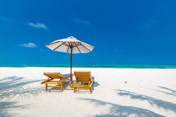 Luxury beach resort, beach loungers near the sea with white sand over sea Topical island background, summer vacation concept, holiday and tourism design. Exotic landscape, inspirational leisure banner