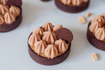 Chocolate tart with caramel and nuts and creamy picks ontop