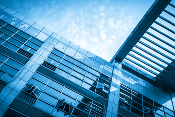 Looking up at the glass facade of a skyscraper