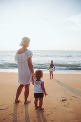 Holiday travel concept, Summer vacations. Happy family are having fun on a tropical beach in sunset.