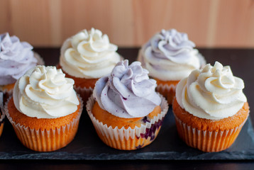 Colorful cupcakes with caramel inside and cream ontop