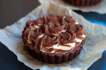 Round coffee-chololate tart on the backing paper