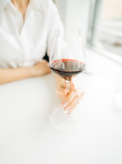 Woman holding  glass of red wine close up
