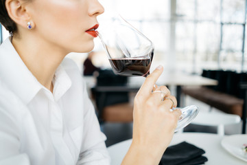 Young woman drinking wine. Ready to drinking red wine from glass