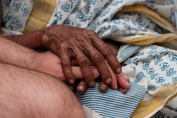 Hands, young and old, on top of each other, comforting each other, Kumrokhali, West Bengal, India