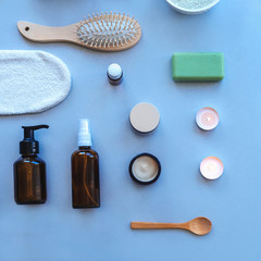 Top view hygiene items and natural cosmetics on blue background. Beauty, spa and wellness concept. Flat lay, copy space.