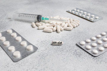 Medical syringe, medicine pills, capsules on concrete background. prescription drug for treatment...