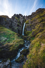 Image of Beautiful Waterfall in Iceland with unique rough landscape taken during bright sunny weather