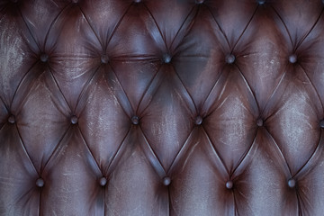 The texture of the upholstery from a genuine leather, close-up, flat view.  Old leather background. 
