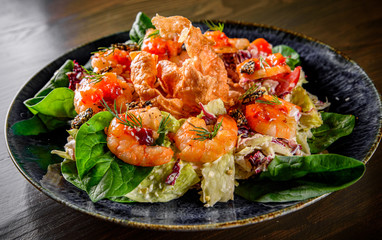 Fresh salad plate with shrimp, tomato, spinach, cabbage and Tangerine Jam in plate on wooden table background