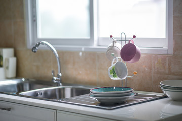Sink in the kitchen and the sun shines through the windows.