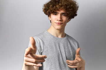 Signs, gestures and symbols concept. Portrait of handsome cool young guy with wavy hair and brown...
