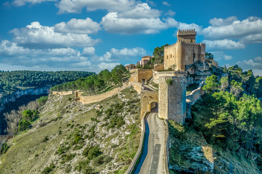 Historic Alarcon castle above the Jucar river with angled tower, multiple gates, donjon and palace on a sunny afternoon in Spain