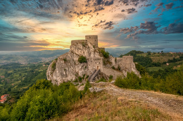 Dramatic sunset view of partially restored ancient Ottoman fortress Srebrenik castle with gate...