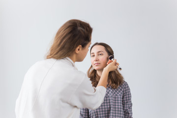 Beauty and cosmetics concept - Makeup artist doing professional make up of young woman