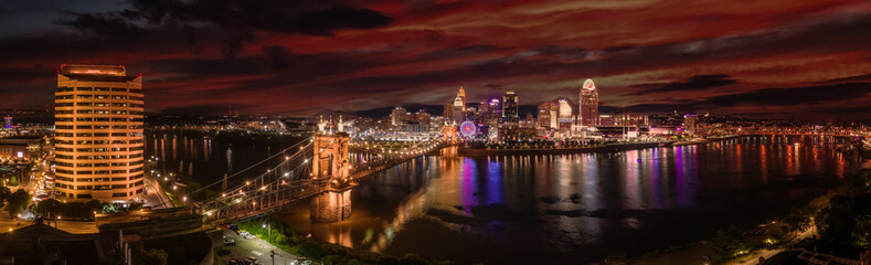 Aerial night time view of Cincinnati with the Roebling bridge stretching over the Ohio river 