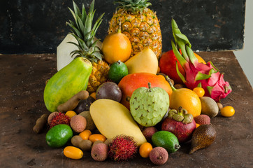 Healthy eating, varieity of tropical fruits on a dark background.