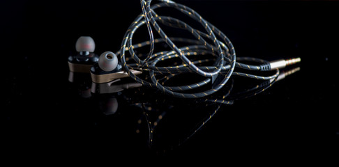 Stereo headphones for the phone against a dark background. Photographed close-up.