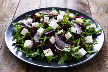  Beetroot salad with goat cheese on wooden background