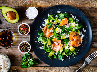 Salmon salad - smoked salmon white rice and vegetables on wooden table