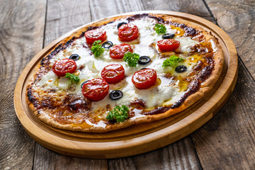 Margherita pizza on wooden background