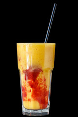 Berry and fruit smoothie with yogurt in a large glass glass on a black background, isolated