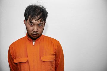 Prisoner in orange robe concept,Portrait of asian handsome man in Prison uniforms,Bandit has a lot of muscle,