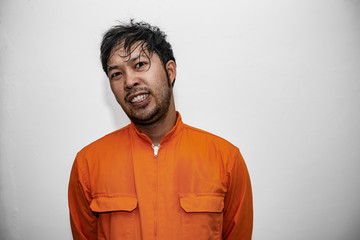 Prisoner in orange robe concept,Portrait of asian handsome man in Prison uniforms,Bandit has a lot of muscle,